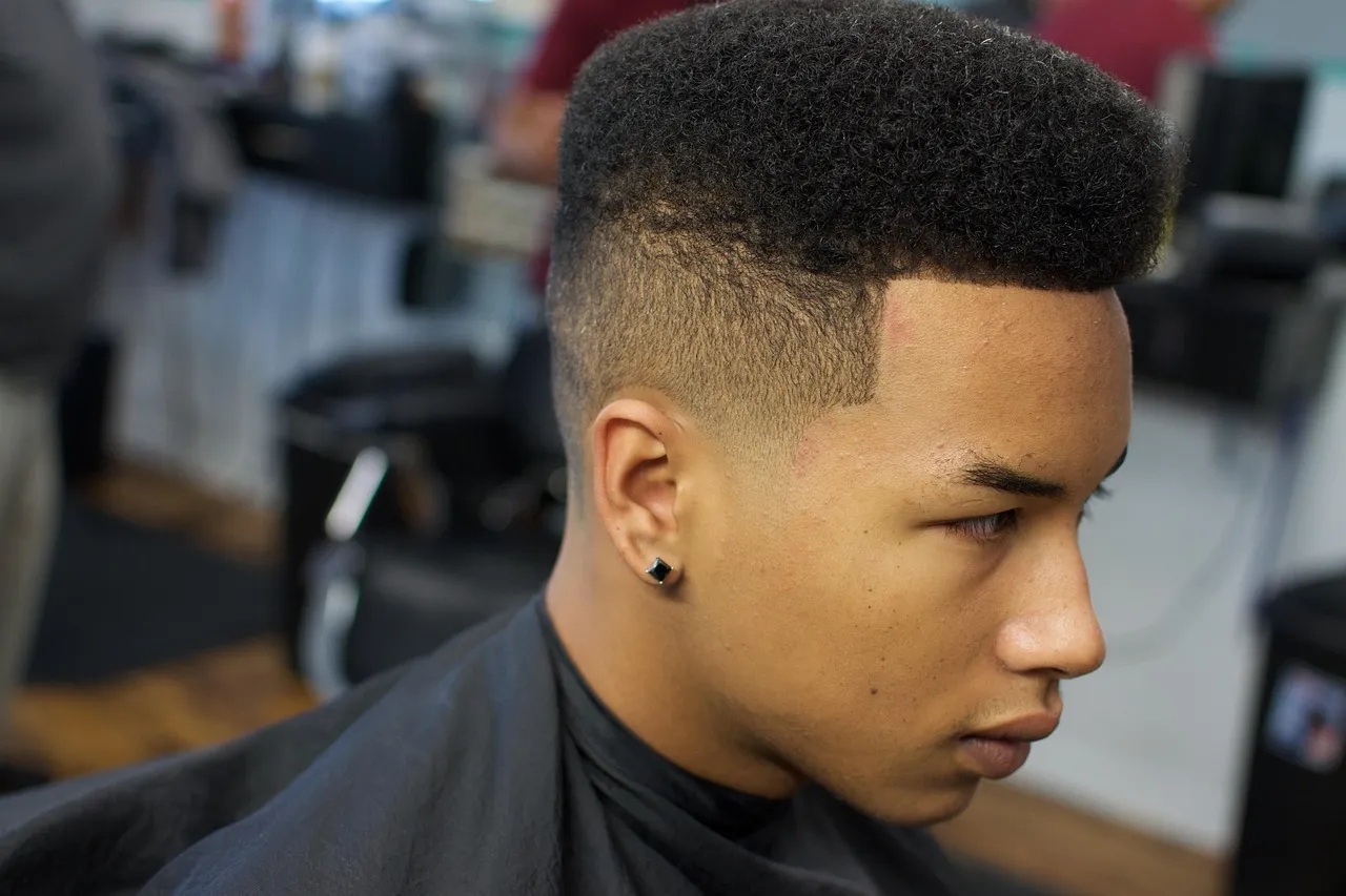 Side profile of a young man with a fresh high-top fade, sharp line-up at the temple