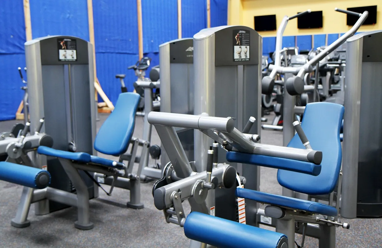 Blue and gray selectorized weight machines on a gym floor