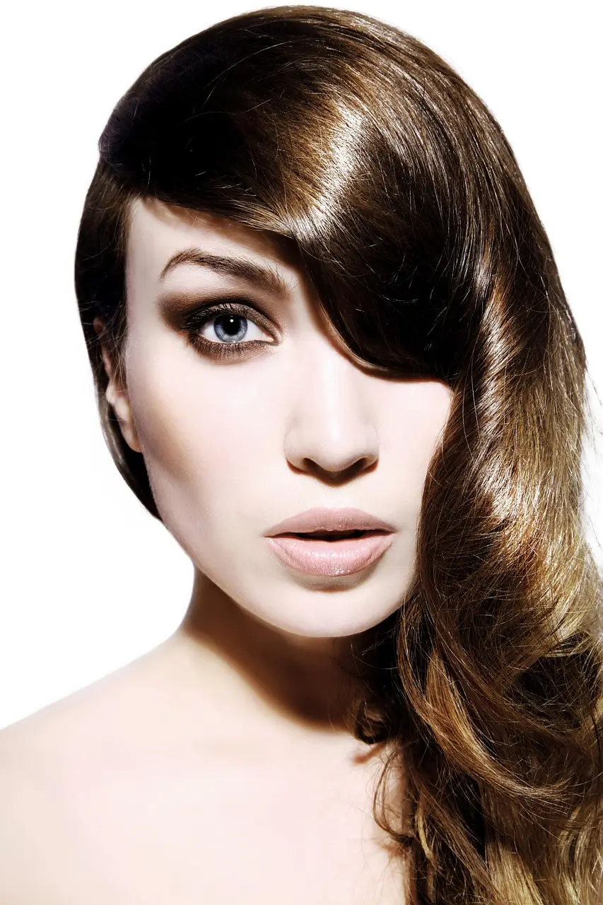 Long glossy chocolate-brown hair swept to one side over the eye